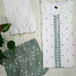 White shirt with green embroidery and green fabric with white patterns on a light background
